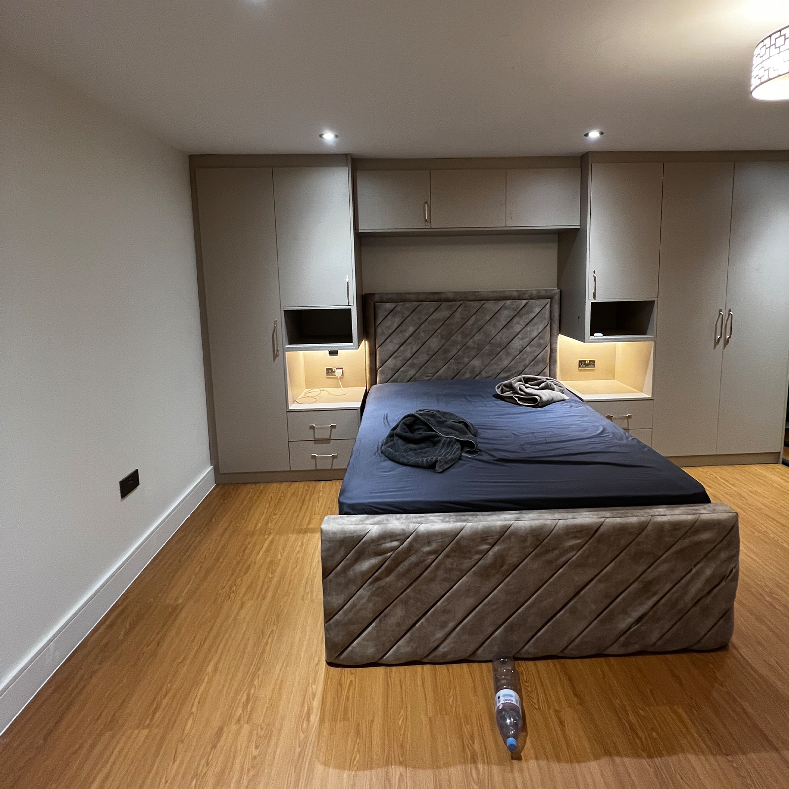 Modern bespoke bedroom with fitted wardrobes, elegant lighting and timeless design