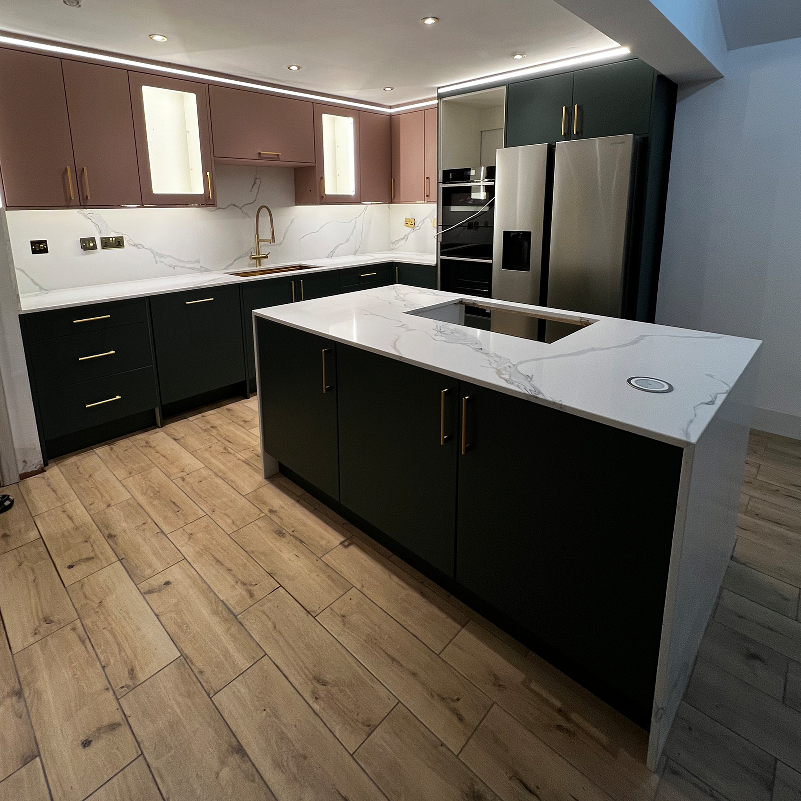 Contemporary kitchen with marble island, brass accents and bespoke cabinetry