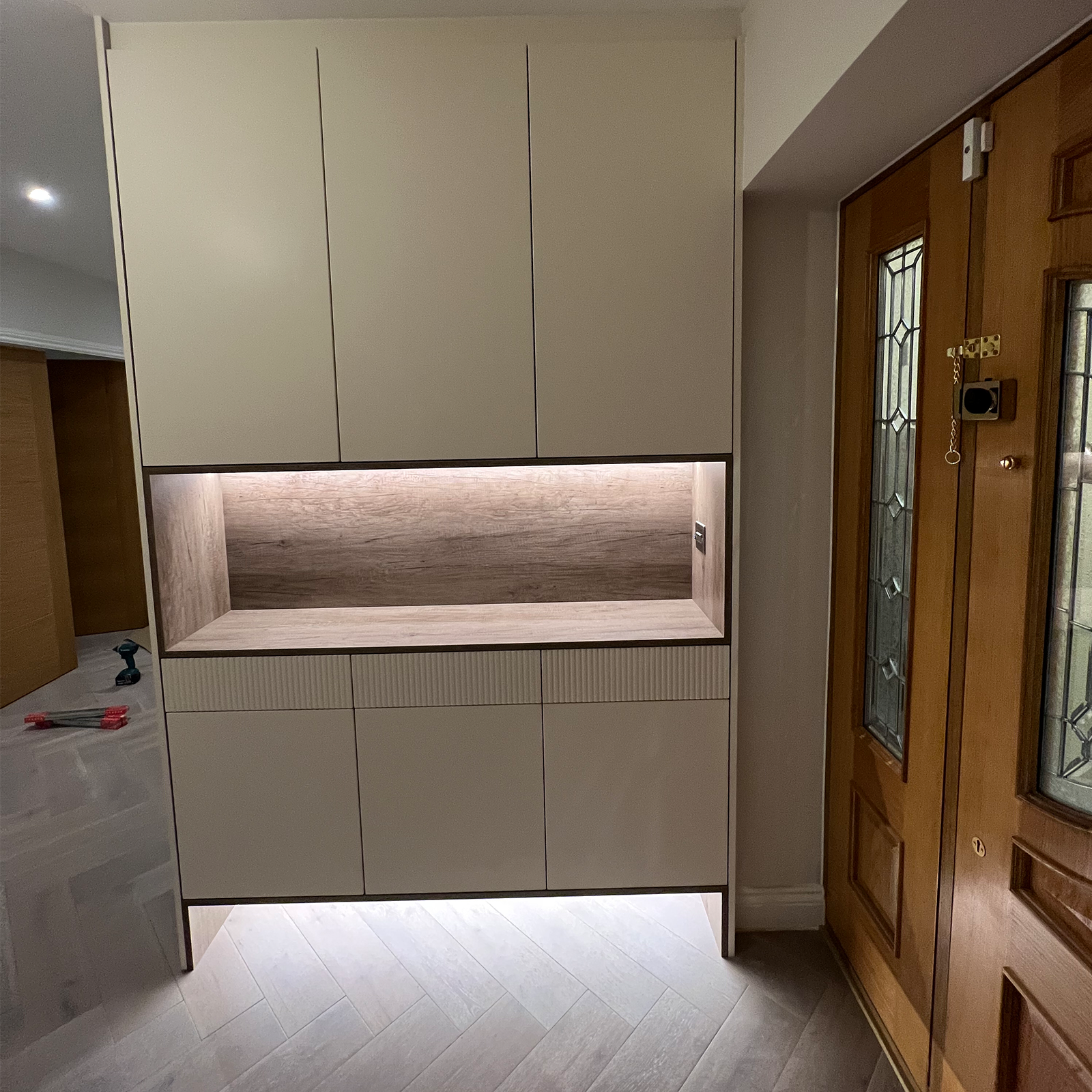 Contemporary built‑in cabinet with recessed shelf and accent lighting design